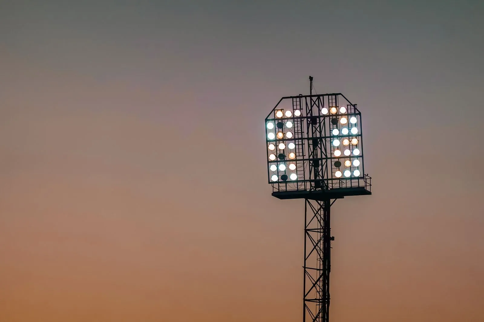 Stadium floodlights against a twilight sky